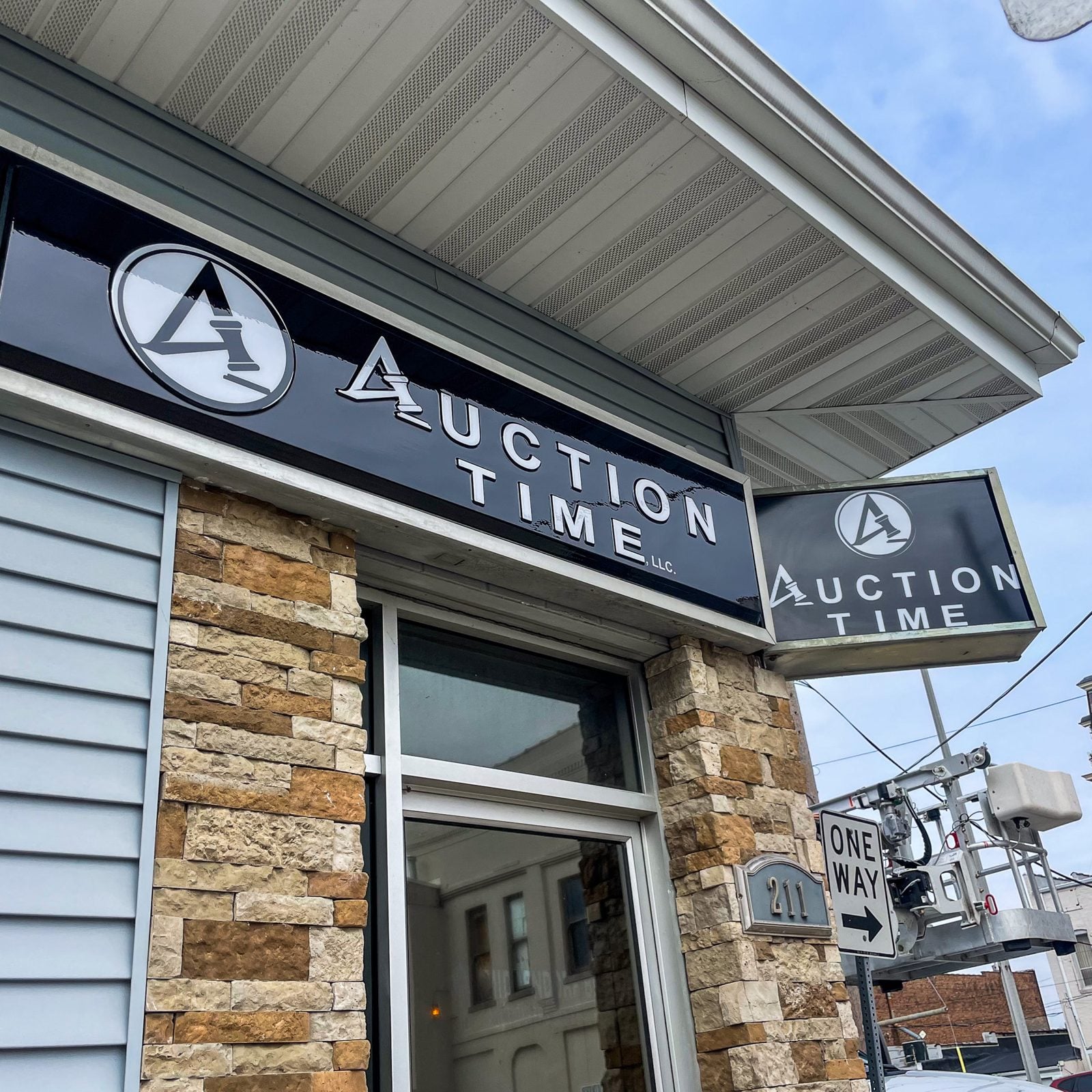 Backlit blade sign and wall cabinets on a stone storefront