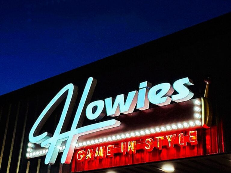 Neon marquee sign for Howies, illuminated at night