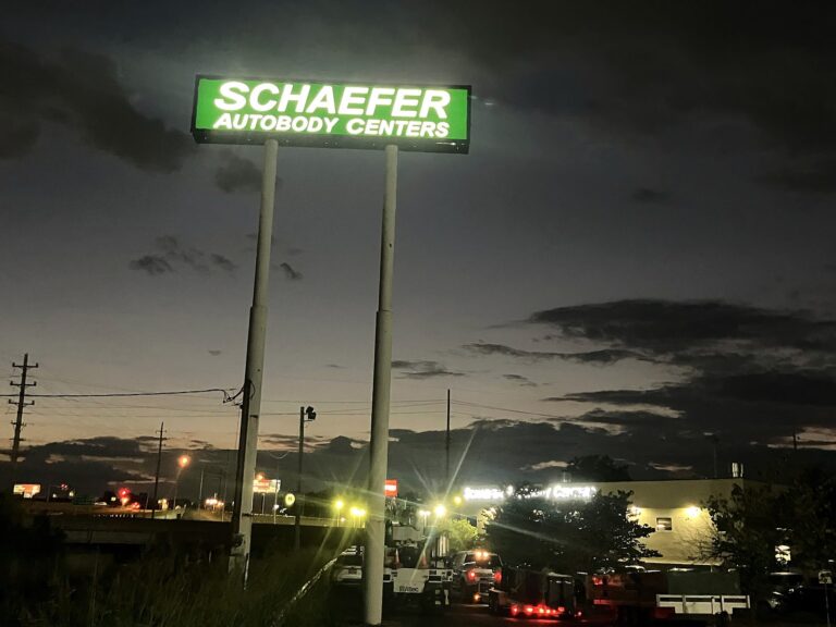 Pylon sign for Schaefer Autobody Centers in O'Fallon, MO, illuminated at night